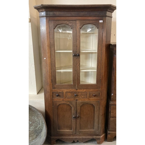 482 - 19th century Welsh oak standing double corner cupboard with moulded cornice over arched glazed doors... 