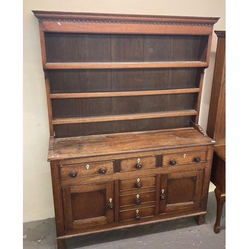 506 - Early 19th century North Wales oak dresser with boarded three shelf rack back over a base of three c... 