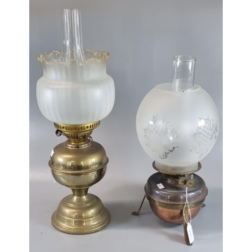 79 - Two early 20th century double burner oil lamps, one standing on a copper reservoir with etched glass... 