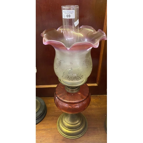 69 - Early 20th Century double oil burner lamp having frosted and cranberry shade above cranberry reservo... 