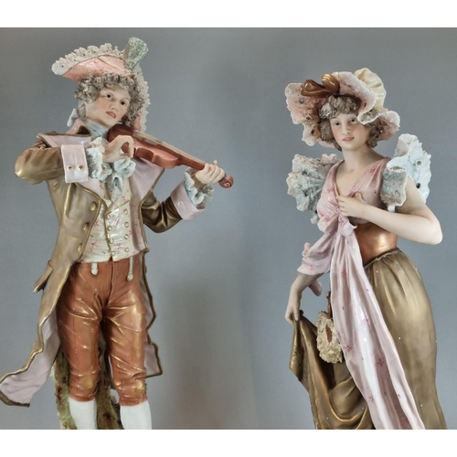 128 - Pair of Royal Dux figures, of a musician playing his violin and a maiden in floral shawl and bonnet.... 