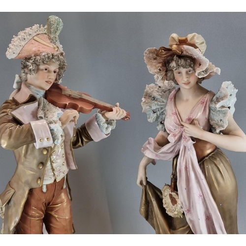 128 - Pair of Royal Dux figures, of a musician playing his violin and a maiden in floral shawl and bonnet.... 