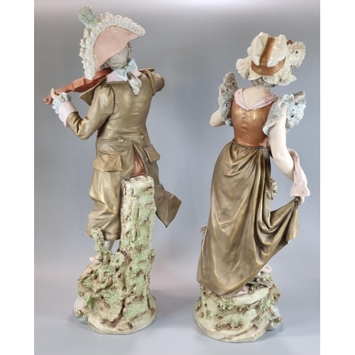 128 - Pair of Royal Dux figures, of a musician playing his violin and a maiden in floral shawl and bonnet.... 