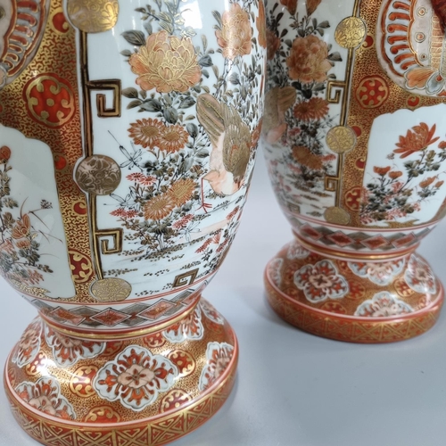 135 - Pair of porcelain Japanese red kutani two handled vases depicting vignettes of birds, flowers, folia... 