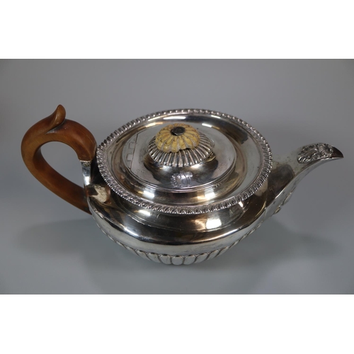 149 - Early 19th century silver baluster shaped teapot with turned wooden handle, engraved armorial and fl... 