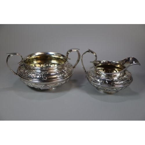 149 - Early 19th century silver baluster shaped teapot with turned wooden handle, engraved armorial and fl... 