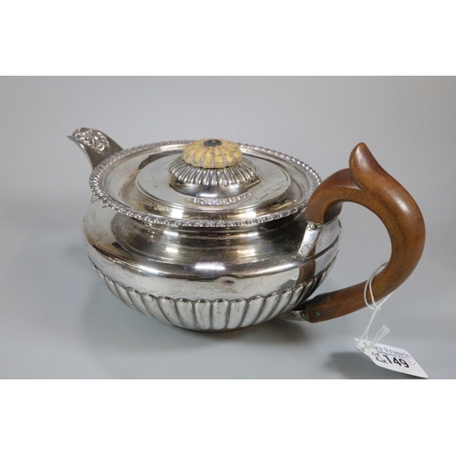 149 - Early 19th century silver baluster shaped teapot with turned wooden handle, engraved armorial and fl... 