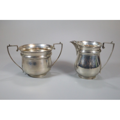 151 - George V silver three piece tea service comprising; two handled sucrier, cream jug and teapot with e... 