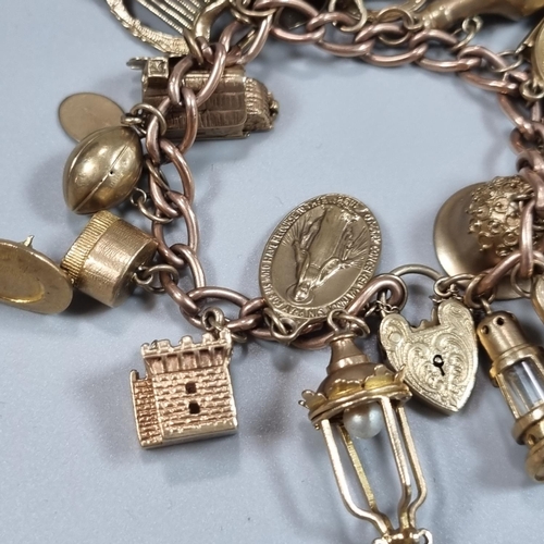 196 - 9ct rose gold curb link charm bracelet with various charms including; football, bottle, heart shaped... 