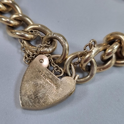 202 - 9ct gold curb link bracelet with heart shaped padlock. 35.2g approx. 
(B.P. 21% + VAT)