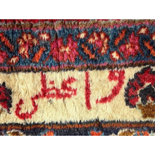 302 - Large red ground Persian Mashad carpet, overall on a red ground with floral and foliate designs, cen... 