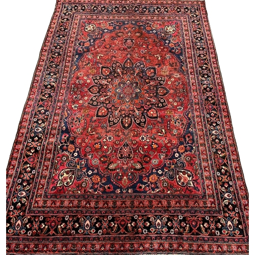 303 - Vintage multi-coloured field Persian Kerman carpet, with central floral medallion and having repeati... 