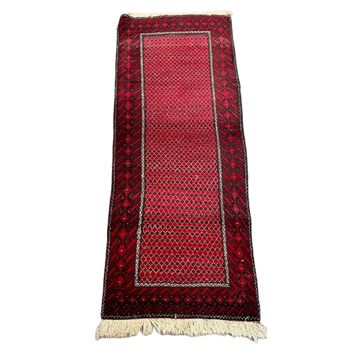 305 - Red and black ground Persian geometric nomadic Beluchi runner. 225 x 81cm approx.
(B.P. 21% + VAT)