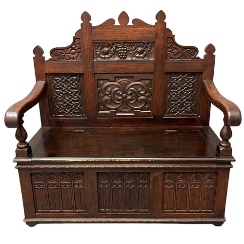 54 - 17th Century style mahogany settle, of small proportions, the high back with carved panels of grapes... 