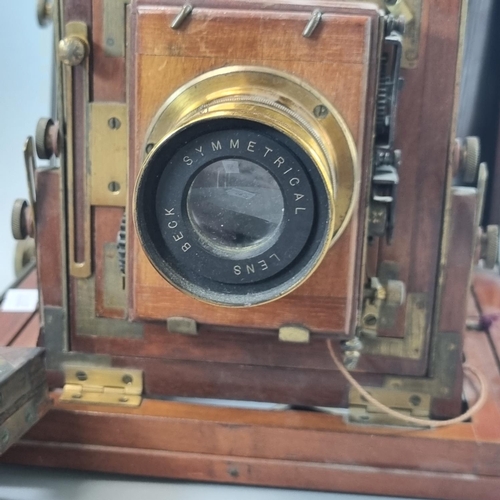 85 - A Beck mahogany brass mounted folding plate camera with 'Beck' symmetrical lens. 6 x 5