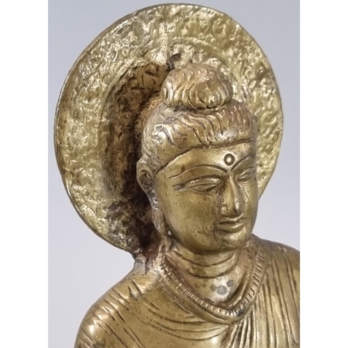 141 - Cast yellow metal Buddha with a halo of enlightenment behind the head, seated in Padmasana, on a pli... 