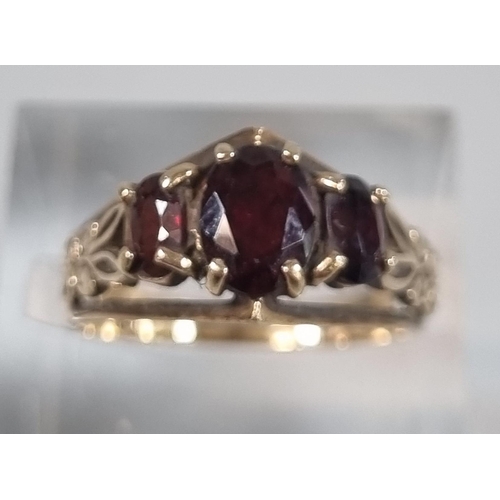 243 - 9ct gold three stone garnet ring.  2.8g approx.  Size L1/2.   (B.P. 21% + VAT)