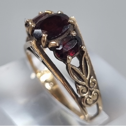 243 - 9ct gold three stone garnet ring.  2.8g approx.  Size L1/2.   (B.P. 21% + VAT)