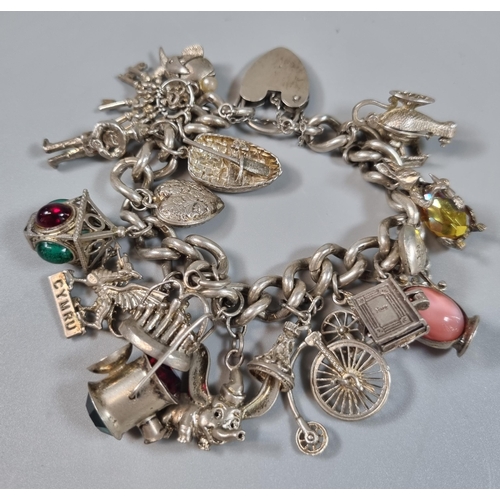 260 - Silver curb link charm bracelet with assorted charms including: bicycle lamp, Welsh dragon, Genie la... 