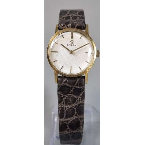 269 - Omega 9ct gold ladies wristwatch, having satin face with baton numerals and leather strap.  Weight o... 