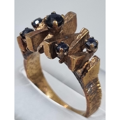 204 - 9ct gold modernist design and blue stone dress ring.  5g approx.  Size K1/2.   (B.P. 21% + VAT)