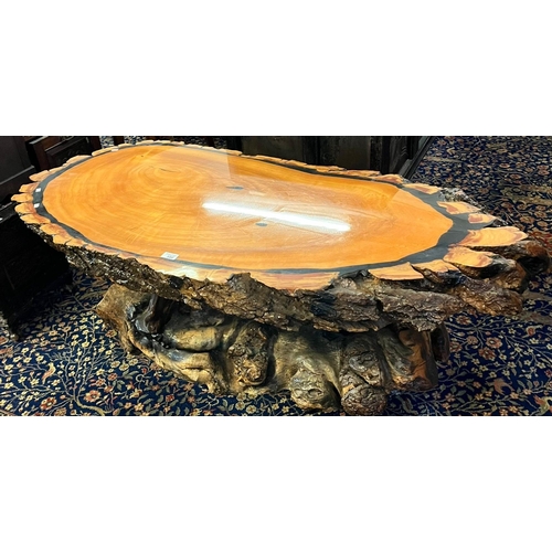 500 - Petrified wood coffee table of oval and rustic form.  Length 140cm approx.  (B.P. 21% + VAT)