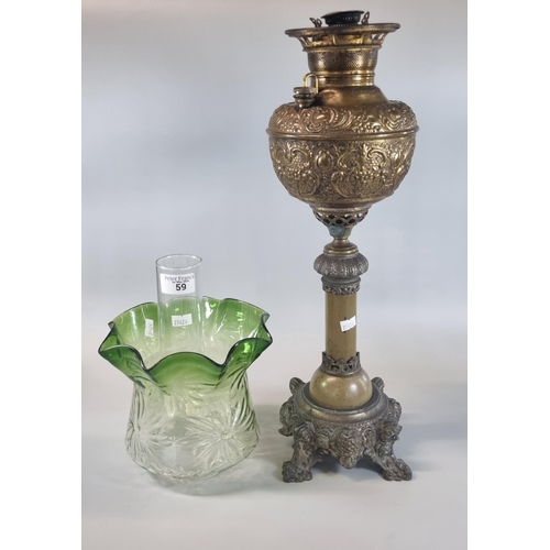 59 - Early 20th century oil burner lamp having green and clear glass shade above a brass repoussé reservo... 