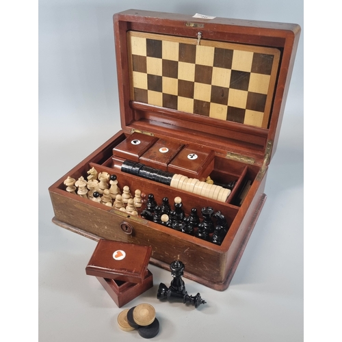 70 - Early 20th century mahogany games compendium, the box containing various chess pieces, card boxes an... 