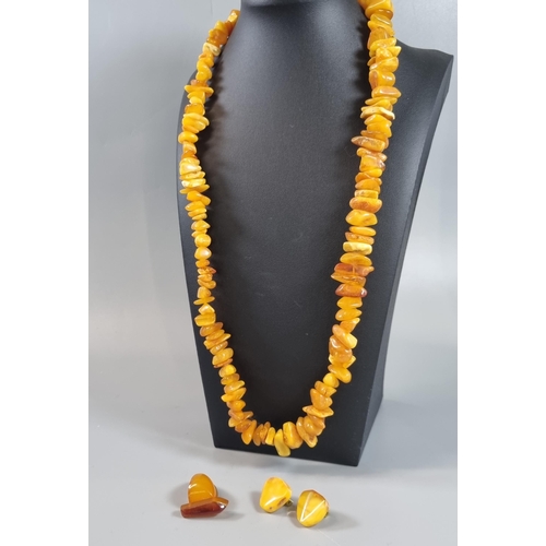 248 - Amber butterscotch necklace (60g approx.) together with a pair of amber clip-on earrings and a novel... 