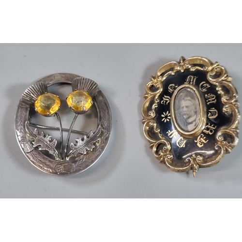 256 - Early Victorian black enamel and yellow metal mourning brooch together with a silver Scottish thistl... 