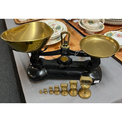 319 - Set of black enamel kitchen scales with brass pans and graduated set of brass bell shaped weights.  ... 