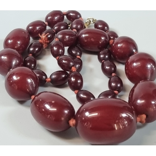 259 - A cherry Bakelite graduated beaded necklace with 9ct gold clasp. 53g approx. (B.P. 21% + VAT)