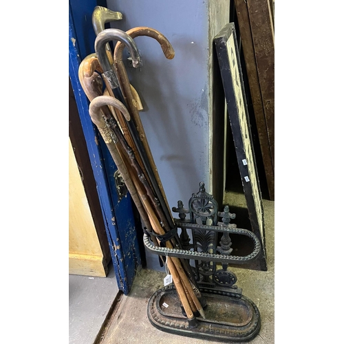 513 - Coalbrookdale style cast iron stick stand together with an assortment of walking sticks, one having ... 