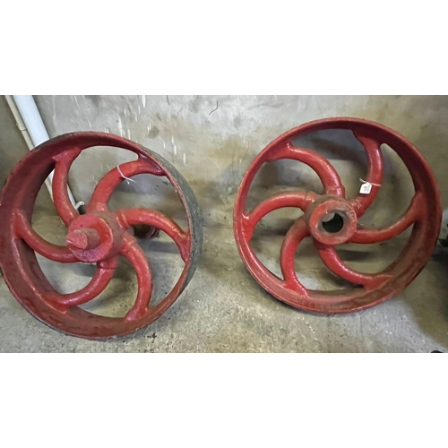 517 - Two heavy cast iron machinery pulley wheels, originally from an agricultural building.  60cm diamete... 