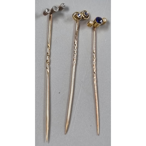 220 - Three Edwardian design gold stick/stock pins, one inset with three diamonds, the others with coloure... 