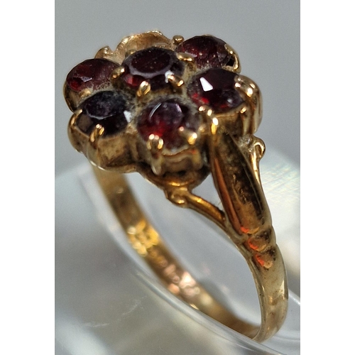 211 - 9ct gold and garnet seven stone flowerhead ring (one stone missing). 2.9g approx. Size O.  (B.P. 21%... 