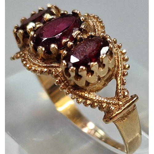 219 - 9ct gold three stone garnet ring, 2.9g approx. Ring size Q (B.P. 21% + VAT)