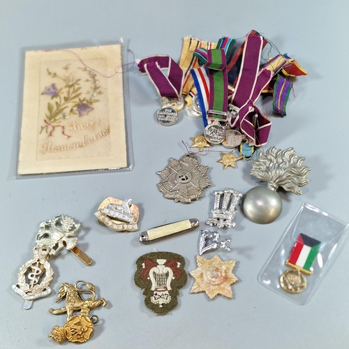 248 - Collection of military items to include: miniature medals, cap badges and a WWI silk postcard (B.P. ... 