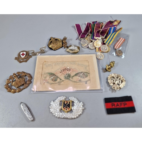 252 - Collection of military items to include miniature medals, cap badges, WWI silk postcard etc. (B.P. 2... 