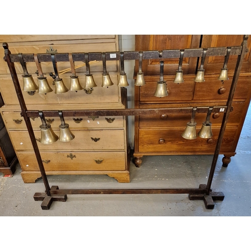 410 - A set of bronze handbells with leather wrist straps, two strikers on a pegged oak display frame. (B.... 