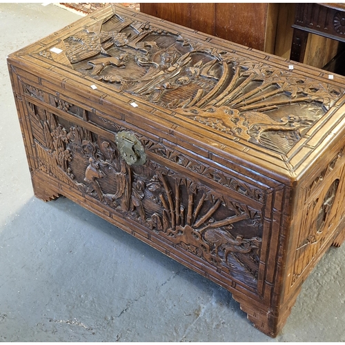 411 - Chinese carved hardwood/camphor wood chest, overall carved with figures in a landscape with pagodas ... 