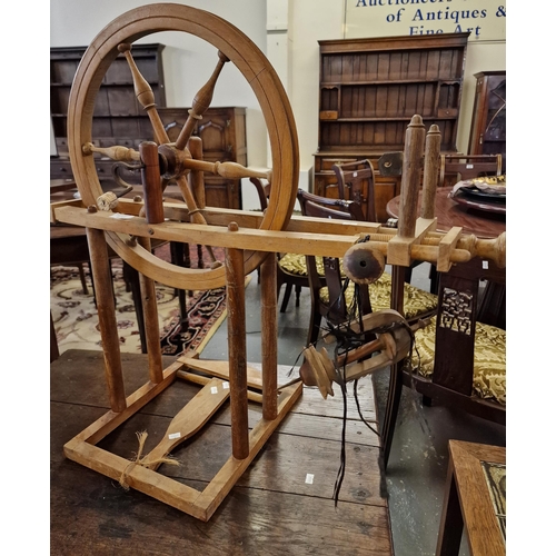 472 - A beech treadle spinning wheel (B.P. 21% + VAT)