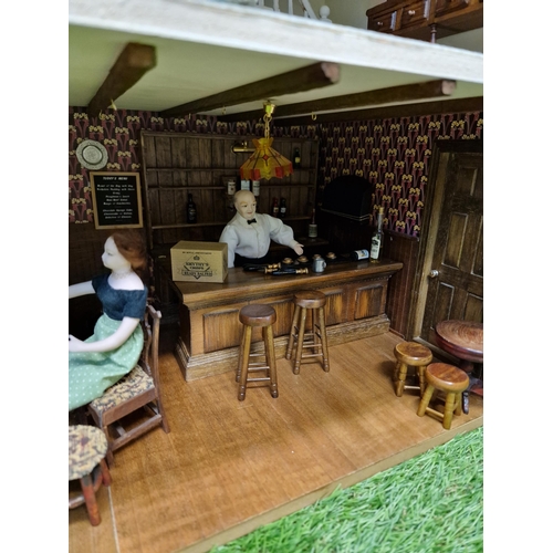 477 - A Victorian style dolls house pub, marked 'The Collie Dog' the interior revealing furnished bar down... 