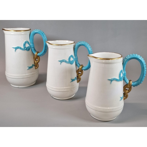 5 - Set of three Victorian porcelain graduated jugs, having gilt rims and turquoise handles with relief ... 