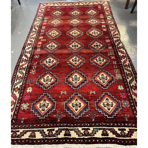 518 - Traditional hand made Afghan design red ground carpet with repeating lozenge geometric designs 153x2... 