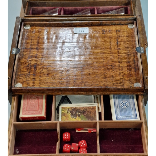 171 - Late Victorian oak three section tantalus and games compendium comprising three cut glass square sec... 