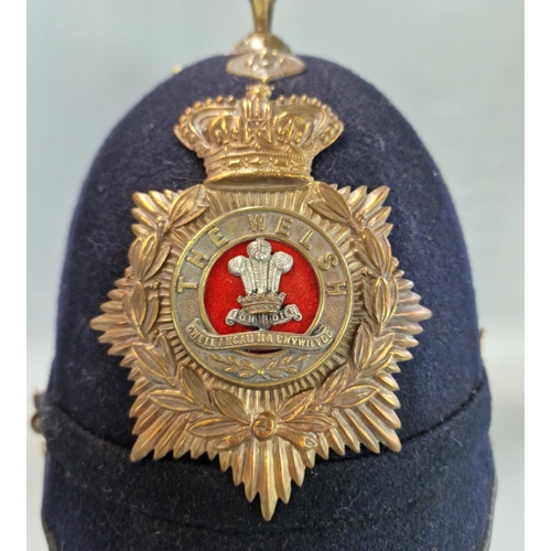 179 - British Victorian blue cloth helmet, with Welsh Regiment brass helmet plate and chin strap.  
Condit... 