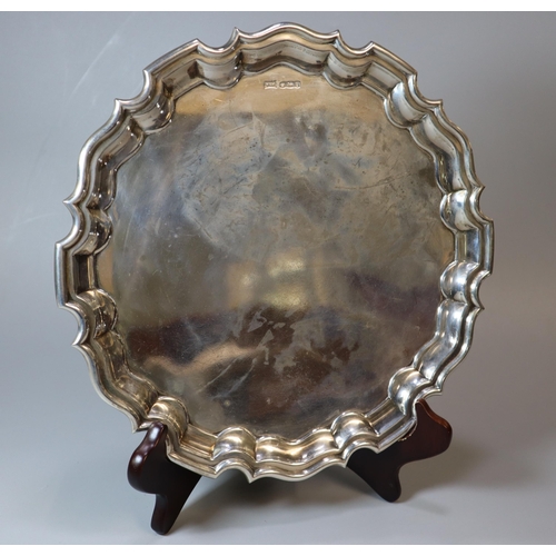 29 - George V silver piecrust salver raised on three scroll feet.  By Walker and Hall, Sheffield 1931. 26... 