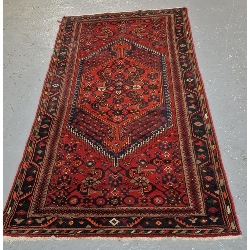 332 - Vintage Shiraz red and navy ground rug, with central geometric medallion and stylised foliate and ge... 