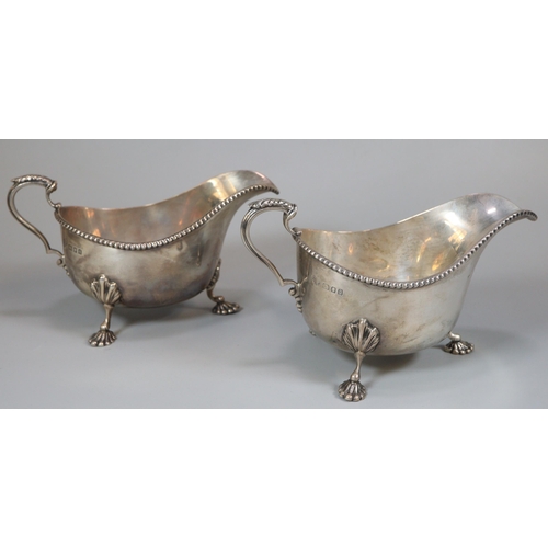 39 - Pair of George V silver gadroon edged sauce boats raised on moulded cabriole legs and paw feet, by T... 